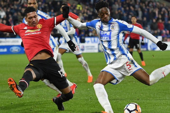 Aksi bek Huddersfield Town, Terence Kongolo (kanan), saat mencoba melepaskan sebuah umpan dari adangan pemain Manchester United, Chris Smalling, dalam pertandingan ronde ke-5 Piala FA 2017-2018 di Stadion John Smith's, Huddersfield, Inggris, pada 17 Februari 2018.