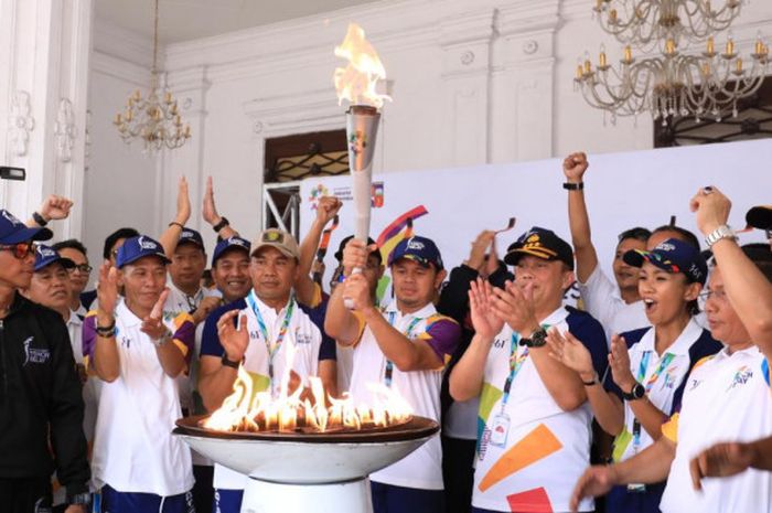 Walikota Bogor, Bima Arya Sugiarto, memegang obor Asian Games 2018 pada kirab obor di Balai Kota Bogor, Jawa Barat, Selasa (14/8/2018)