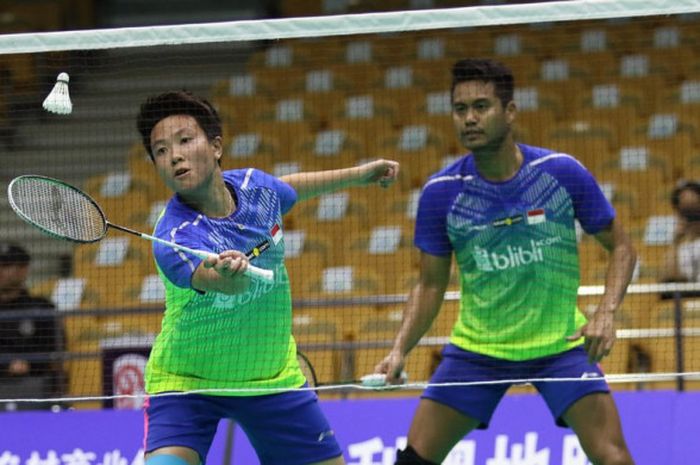  Pasangan ganda campuran nasional Indonesia, Tontowi Ahmad (belakang)/Liliyana Natsir, mengembalikan shuttlecock dari pasangan lawan, Tinn Isriyanet/Pacharapun Chochuwong (Thailand), pada laga babak kedua Kejuaraan Asia 2018 di Wuhan Sports Center, Wuhan, China, Kamis (25/4/2018). 