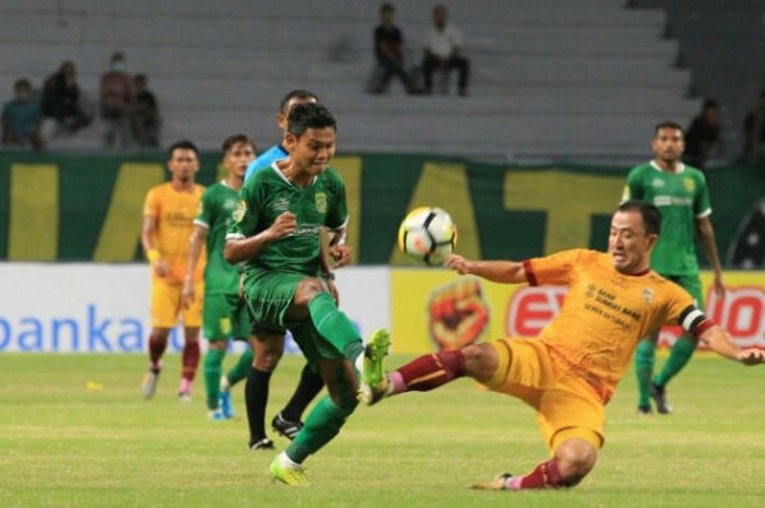 Pemain Persebaya, Fandi Eko Utomo (kiri) berebut bola dengan pilar asing Sriwijaya FC, Yu Hyun-koo pada laga pamungkas Grup B Piala Gubernur Kaltim 2018 di Stadion Batakan, Balikpapan, Rabu (28/2/2018) malam.