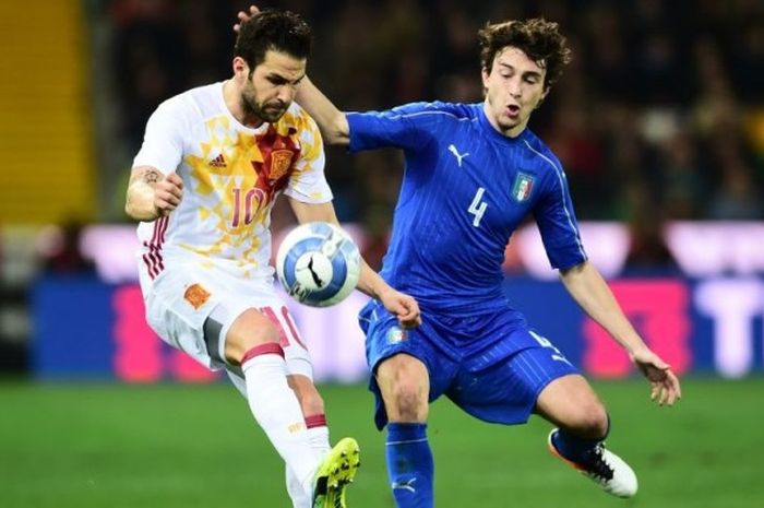 Bek Italia, Matteo Darmian, berduel dengan gelandang Spanyol, Cesc Fabregas, pad alaga persahabatan di Udinese, Italia, pada 24 Maret 2016.