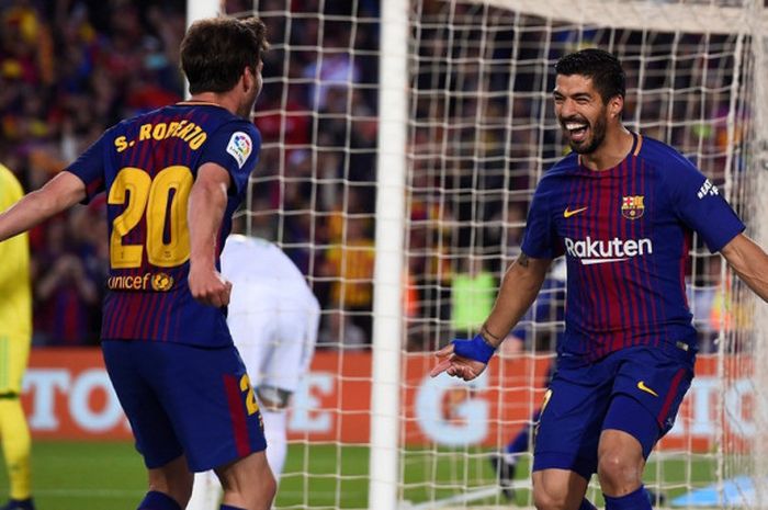 Penyerang FC Barcelona, Luis Suarez (kanan), merayakan golnya bersama Sergi Roberto dalam laga Liga Spanyol kontra Real Madrid di Stadion Camp Nou, Barcelona pada 6 Mei 2018.