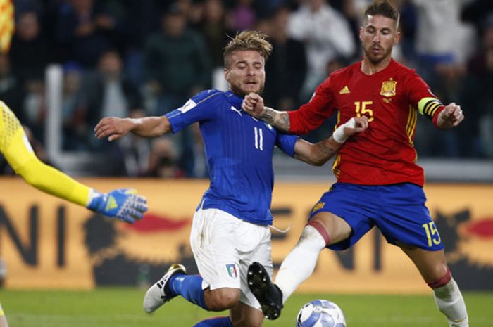 Penyerang Italia, Ciro Immobile (tengah), berjuang melawan bek Spanyol, Sergio Ramos , dan kiper David de Gea dalam laga Kualifikasi Piala Dunia 2018 di Juventus Stadium, Turin, pada 6 Oktober 2016 . Skor 1-1.