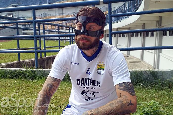 Bek Persib, Bojan Malisic mencoba menggunakan topeng pelindung milik rekannya di Persib pada sesi latihan di Stadion GBLA, Kota Bandung, Kamis (12/4/2018).