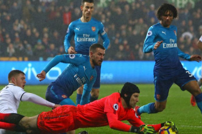 Kiper Arsenal, Petr Cech, mengamankan bola pada pertandingan Liga Inggris versus Swansea City di Stadion Liberty, Rabu (31/1/2018) dini hari WIB.