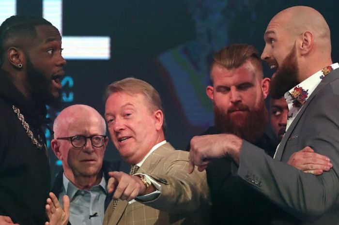 Juara dunia kelas berat versi WBC asal Amerika Serikat, Deontay Wilder (kiri), dan mantan juara dunia kelas berat dari Inggris, Tyson Fury, dipisahkan promotor Frank Warren pada sesi jumpa pers di London, Inggris, Senin (1/10/2018).