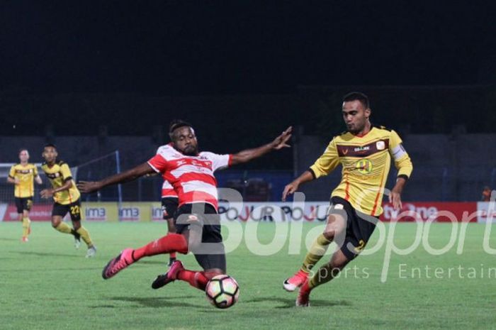  Aksi pemain Madura United, Engelberd Sani, versus kapten Barito Putera, Rizky Pora, pada lanjutan l