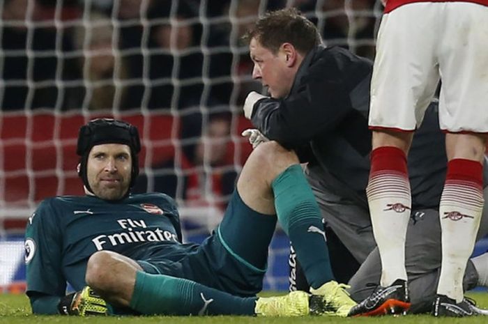 Kiper Arsenal, Petr Cech, menerima perawatan dari tim medis dalam partai Liga Inggris melawan Everton di Stadion Emirates, London, 3 Februari 2018.