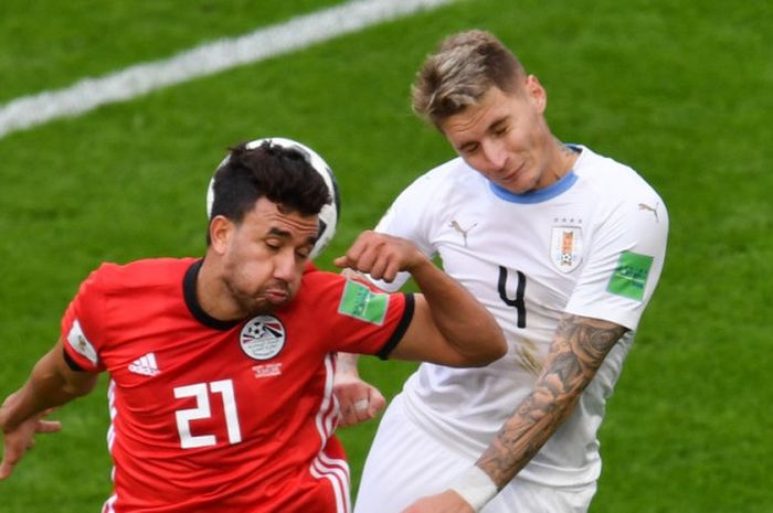 Bek Uruguay, Guillermo Varela, (kanan) dan pemain depan Mesir, Mahmoud 'Trezeguet' Hassan (kiri), berduel udara pada laga Piala Dunia 2018 antara Mesir kontra Uruguay di Stadion Ekaterinburg Arena, Jumat (15/6/2018).