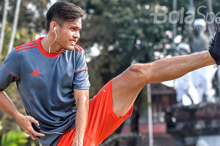 Bek Persija, Muhamad Rezaldi Hehanusa melakukan peregangan kakinya usai berlari sendirian di Lapangan Puputan Denpasar, Rabu (13/9/2017) pagi.