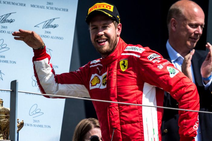 Sebastian Vettel  merayakan podium GP Inggris di Sirkuit Silverstone, Inggris, Minggu (8/7/2018).