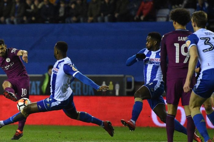 Striker Manchester City, Sergio Aguero (kiri), melepaskan tendangan dalam laga babak kelima Piala FA kontra Wigan Athletic di Stadion DW, Wigan, Inggris, pada 19 Februari 2018.