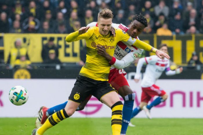 Gelandang Borussia Dortmund, Marco Reus (depan), berjibaku melawan pemain Hamburg SV, Gideon Jung, saat kedua tim bertemu pada pertandingan Liga Jerman di Stadion Signal Iduna Park, Dortmund, Jerman, Sabtu (10/2/2018).