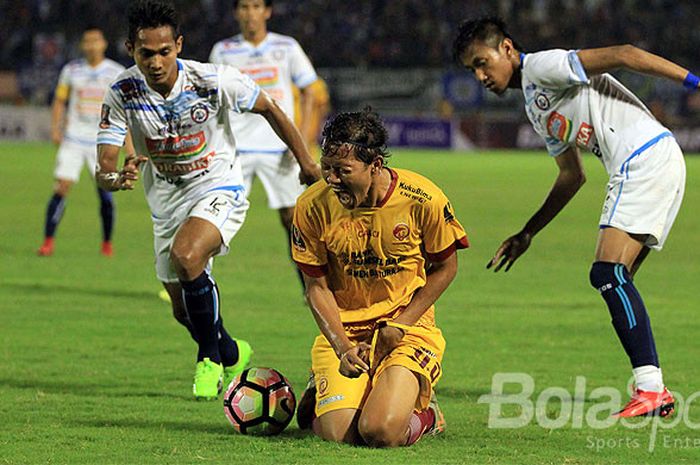 Gelandang Sriwijaya FC, Adam Alis (tengah), meringis kesakitan seusai ditekel pemain Arema FC dalam laga babak 8 Besar Piala Presiden 2018 di Stadion Manahan Solo, Jawa Tengah, Minggu (04/02/2018) malam.