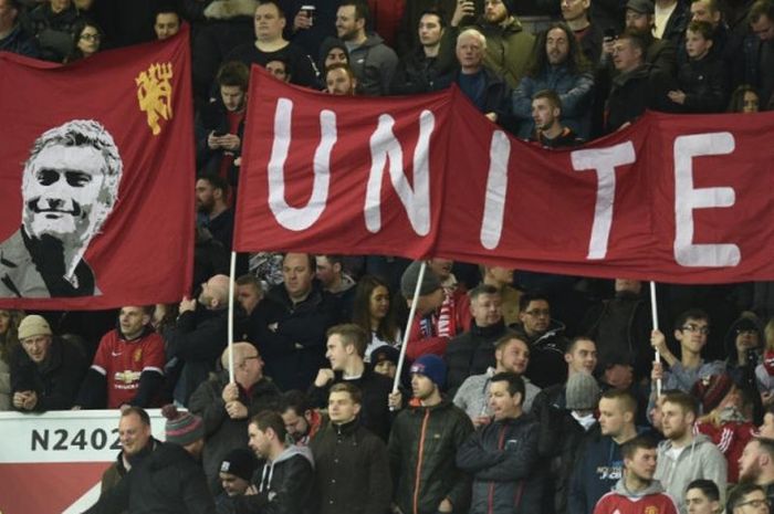 Suporter Manchester United membentangkan spanduk bergambar wajah pelatih Jose Mourinho dalam partai Liga Inggris melawan West Ham United di Old Trafford, 27 November 2016.