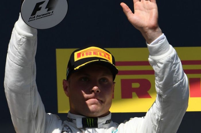 Pebalap Mercedes asal Finlandia, Valtteri Bottas, mengangkat trofi yang diraihnya setelah finis di urutan ketiga GP Hungaria, Minggu (30/7/2017).