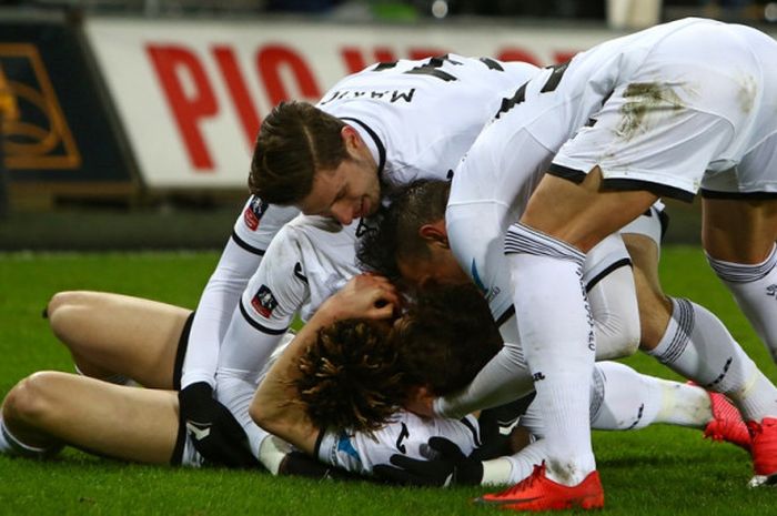 Para pemain Swansea City merayakan gol yang dicetak oleh Daniel James (bawah) dalam laga ulangan babak keempat Piala FA kontra Notts County di Stadion Liberty, Swansea, pada 6 Februari 2018.