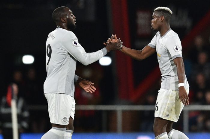 Gelandang Manchester United, Paul Pogba (kanan), bersalaman dengan Romelu Lukaku seusai ditarik keluar lapangan dalam laga Liga Inggris kontra Bournemouth di Stadion Vitality, Bournemouth pada 18 April 2018.