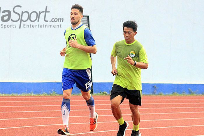 Striker anyar Persib, Jonathan Bauman (kanan) ditemani pelatih fisik Yaya Sunarya (kanan) saat berlatih di Stadion Arcamanik, Kota Bandung, Senin (19/3/2018).