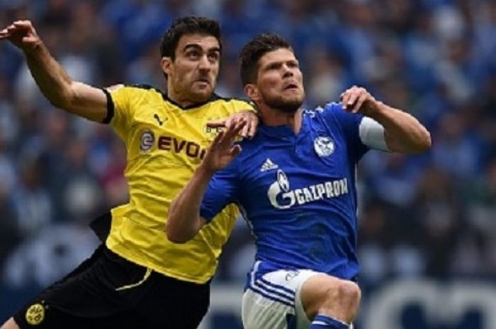  Sokratis (Dortmund) dan Klaas Jan Huntelaar (Schalke) berduel udara pada laga di Veltins Arena, Minggu (10/4/2016).  