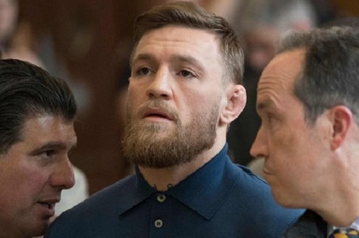  Conor McGregor (tengah) saat didampingi pengacaranya, Jim Walden (kanan) dan John Arlia (kiri) pada persidangan yang digelar di Brooklyn, New York, Amerika Serikat, pada Jumat (6/4/2018). 