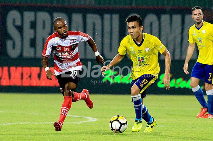 Aksi gelandang Barito Putera, Paulo Oktavianus Sitanggang (kanan), saat menggiring bola dibayangi gelandang Madura United, Zah Rahan Krangar, pada laga perdana Liga 1 2018 di Stadion Gelora Ratu Pamelingan, Pamekasan, Madura, Senin (26/03/18).