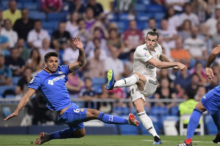 Aksi penyerang Real Madrid, Gareth Bale (tengah), saat melepaskan tembakan ke gawang Getafe dengan latar belakang bangku penonton yang sedikit lowong dalam pertandingan La Liga Spanyol 2018-2019 di Stadion Santiago Bernabeu, Madrid, Spanyol, pada 19 Agustus 2018.