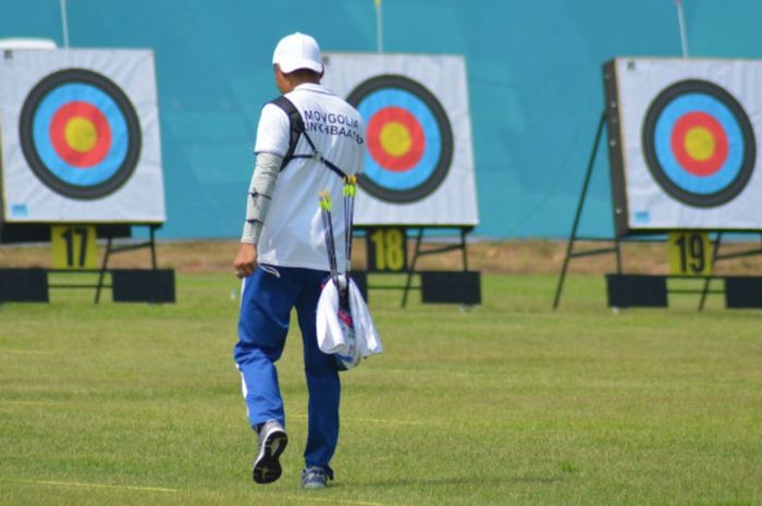 Atlet panahan nomor recurve putra dari Mongolia, Munkhbaatar Namjilmaa, saat akan mengambil anak panah dari target.