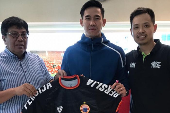 Direktur Utama Persija Jakarta Gede Widiade (kiri) memperkenalkan Ryuji Utomo (tengah) sebagai pemain baru setelah hengkang dari klub Liga 1 Thailand, PTT Rayong. 