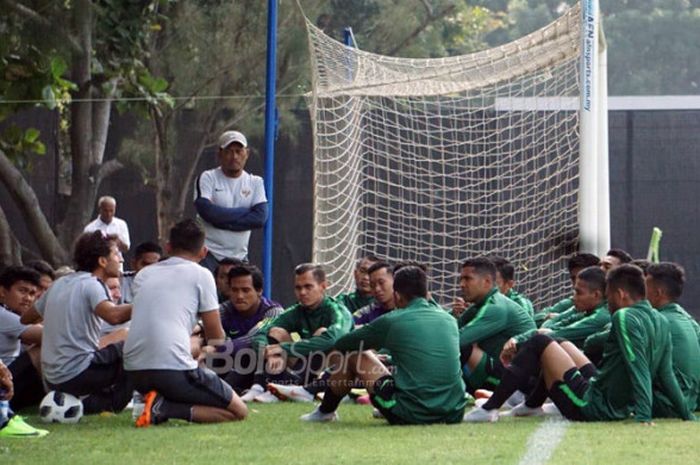 Pelatih timnas U-23 Indonesia, Luis Milla (ketiga dari kiri/menduduki bola), berbicara kepada para pemain sebelum memulai sesi latihan di Lapangan ABC, Senayan, Jakarta, Kamis (16/8/2018).