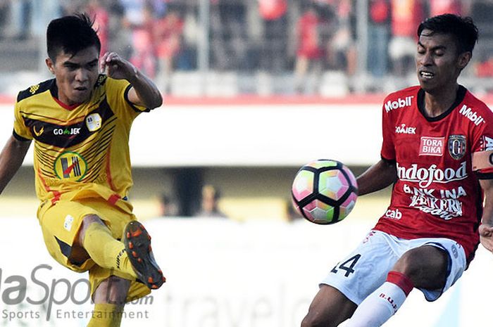 Kapten Bali United, Fadil Sausu (kanan) berusaha menghadang bola sepakan dari gelandang Barito Putra, Paulo Sitanggang saat kedua tim bentrok di Stadion Kapten I Wayan Dipta, Gianyar, Jumat (14/7/2017). Dilaga ini Bali United menang 4-0.