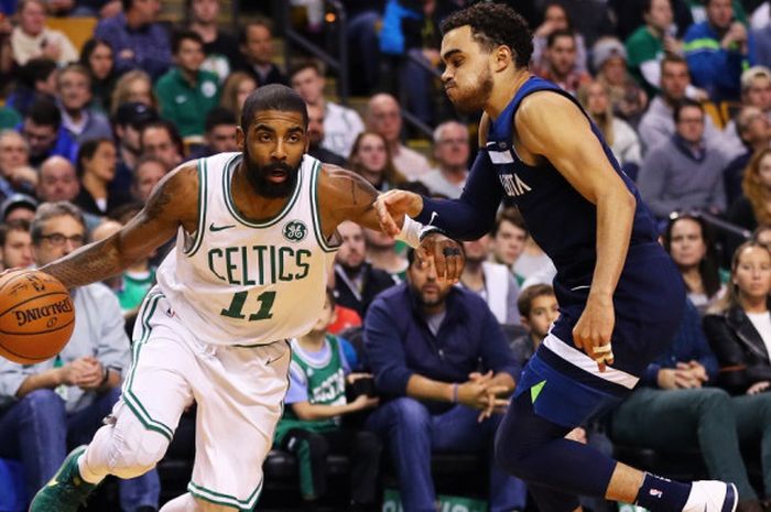 Pebasket Boston Celtics, Kyrie Irving (jersey putih, #11), berupaya melewati penjagan pemain Minnesota Timberwolves, Tyus Jones (#1), pada laga yang berlangsung di TD Garden, Boston, Massachusetts, Jumat (5/1/2018) malam waktu setempat. Celtics menang dengan skor 91-84.