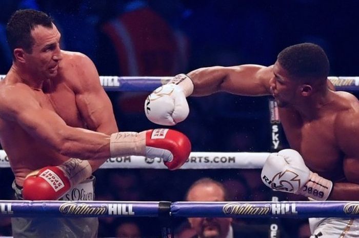 Petinju Inggris, Anthony Joshua (kiri), melancarkan pukulan ke arah petinju Ukraina, Wladimir Klitschko, pada ronde keempa pertandingan kelas berat di Wembley Stadium, London, Sabtu (20/4/2017).