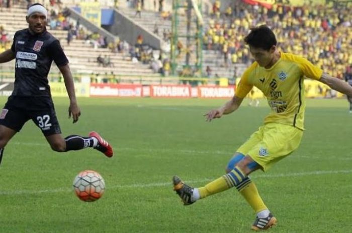 Bek PBFC, Leonard Tupamahu (kiri) mencoba menghadang bola sepakan gelandang Persegres, Oh In-kyun di Stadion Tri Dharma, Gresik, 16 Oktober 2016. 