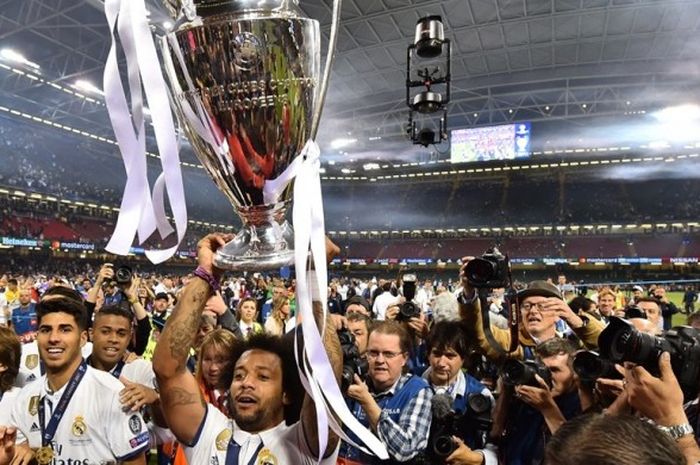 Marcelo mengangkat trofi Liga Champions setelah Real Madrid menang 4-1 atas Juventus pada partai final di Stadion Millenium, Cardiff, Sabtu (3/6/2017).