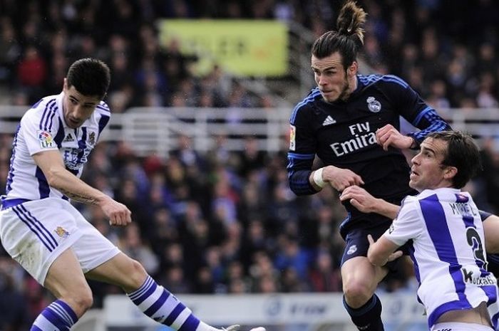 Pemain Real Madrid, Gareth Bale (tengah), berduel dengan pemain Real Sociedad dalam lanjutan La Liga di Estadio Municipal de Anoeta, Sabtu (30/4/2016).