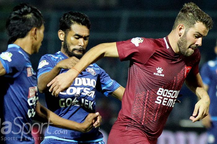 Marc Anthony Klok (PSM Makassar) sedang berusaha melepaskan diri dari hadangan dua pemain Arema FC.