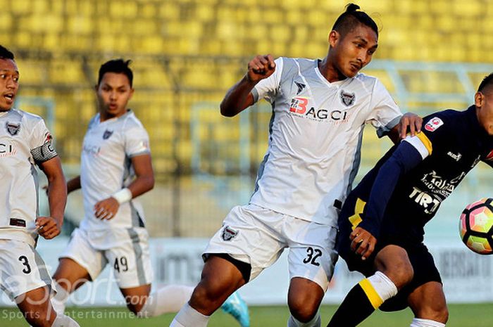 Pemain Madura FC, Ahmad Mahrus Bahtiar (kedua dari kanan), berupaya merebut bola dari penguasaan pemain Persekam Metro FC, Setyo Adi Prastowo, dalam laga pekan ke-8 Liga 2 di Stadion Kanjuruhan Malang, Jawa Timur, (22/07/2017).