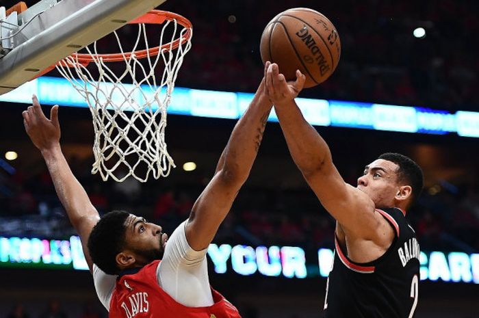 Center New Orleans Pelicans, Anthony Davis (jersey merah, #23), memblok tembakan dari pemain Portland Trail Blazers, Wade Baldwin IV, pada laga gim keempat babak kesatu play-off NBA 2018 yang berlangsung di Smoothie King Center, New Orleans, Louisiana, Amerika Serikat, Sabtu (21/4/2018). Pelicans menang 131-123.