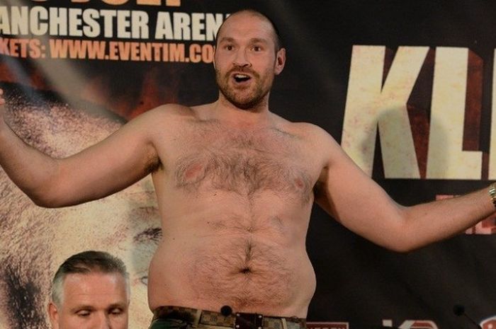 Petinju asal Inggris, Tyson Fury, membuka bajunya saat menghadiri sesi konferensi pers menjelang laga kontra Wladimir Klitschko (Ukraina), di Manchester Arena, Manchester, Inggris, 27 April 2016.