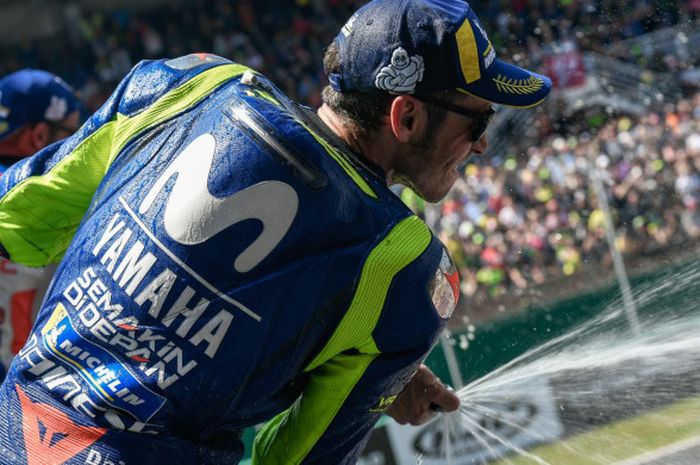 Pebalap Movistar Yamaha, Valentino Ross, menyemburkan isi sampanye saat merayakan keberhasilannya finis di posisi ketiga pada balapan seri kelima MotoGP Prancis di Sirkuit Le Mans, Minggu (20/5/2018).