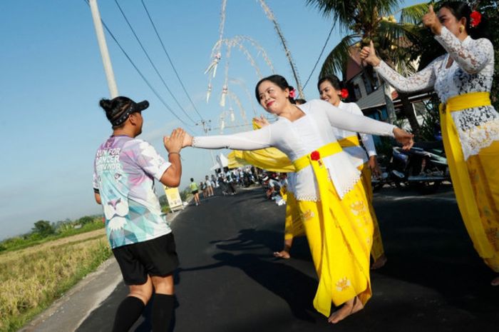 Penari yang membawakan Tari Rejang Renteng di Desa Banjarakan menyapa peserta Maybank Bali Marathon 2018 yang digelar pada Minggu (9/9/2018).