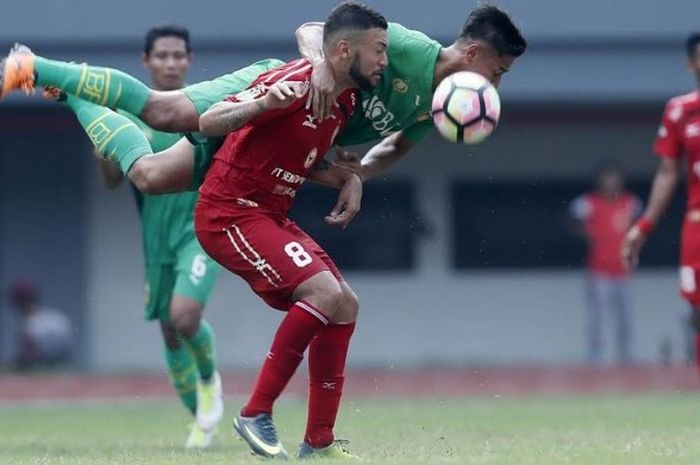 Bek Bhayangkara FC, Indra Kahfi 'terbang' saat mencoba menghentikan pergerakan striker Semen Padang, Marcel Sacramento pada laga pekan ketujuh Liga 1 musim 2017 di Stadion Patriot, Kota Bekasi, Sabtu (20/5/2017) sore.  