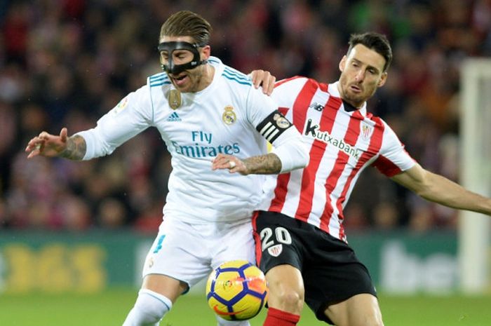 Bek Real Madrid, Sergio Ramos (kiri), berduel dengan striker Athletic Bilbao, Aritz Aduriz, dalam laga Liga Spanyol di Stadion San Mames, Bilbao, pada 2 Desember 2017.