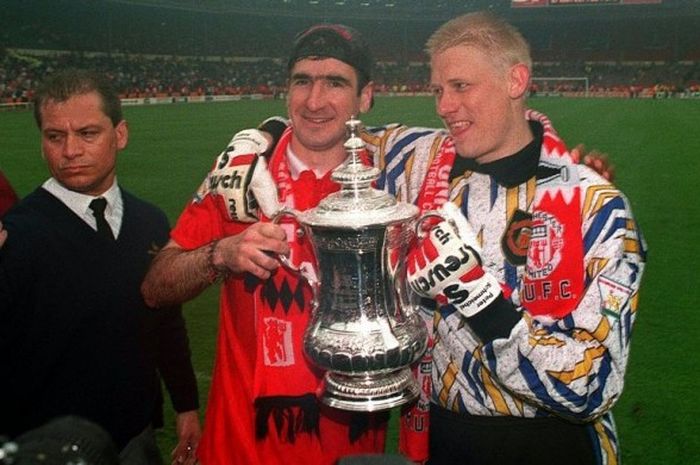  Peter Schmeichel (kanan) berpose bersama Eric Cantona dengan memegang trofi Piala FA yang dimenangi Manchester United usai menekuk Chelsea di final, 14 Mei 1994. 