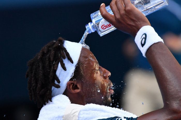 Petenis tunggal putra Prancis, Gael Monfils, mengguyur wajahnya dengan air untuk mendinginkan suhu badannya saat bertanding melawan Novak Djokovic di bawah temperatur kota Melbourne yang mencapai 39 derajat Celcius pada Kamis (18/1/2018).