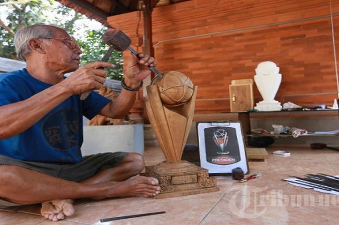 Pemahat, Ida Bagus Lasem menyelesaikan trofi piala presiden di Desa Kemenuh, Gianyar, Sabtu (26/9/2015).Trofi yang berbahan dasar kayu jati Bojonegoro ini akan diberikan Presiden Jokowi kepada tim Juara Piala presiden 2015 di Gelora Bung Karno oktober mendatang. Saat ini proses pengerjaan trofi mencapai 90 persen. 