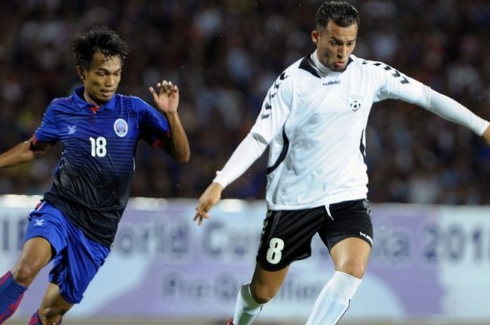 Pemain Afghanistan, Faysal Shayesteh (kanan), menggiring bola demi menjauh dari pemain Kamboja, Sos Suhana, dalam pertandingan kualifikasi Piala Dunia 2018 Grup E di National Olympic Stadium, Phnom Penh, Kamboja, pada 16 Juni 2015.