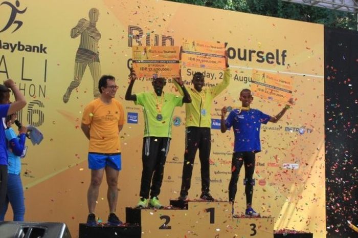 Pelari asal Indonesia, Agus Prayogo, berdiri di atas podium kemenangan saat menerima penghargaan di nomor lari half-marathon Maybank Bali Marathon 2016 di Bali Safari & Marine Park, Gianyar, Bali, Minggu (28/8/2016).