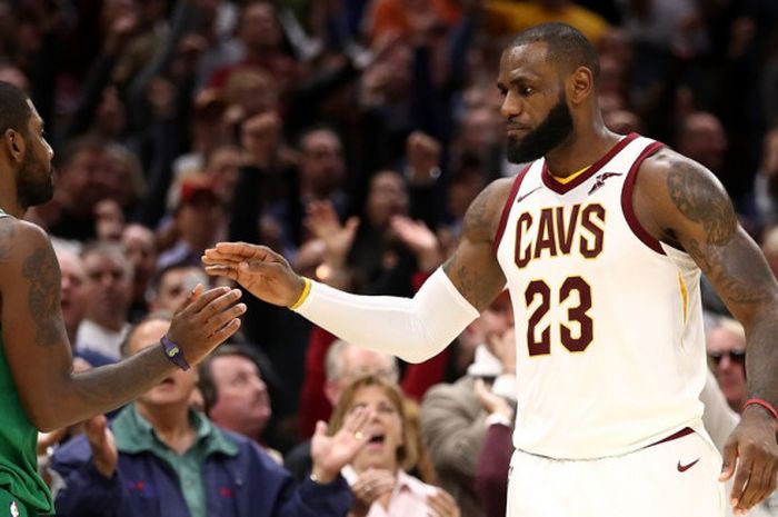 Pebasket Cleveland Cavaliers, LeBron James (jersey putih, #23), bersalaman dengan mantan rekan setimnya yang kini bermain untuk Boston Celtics, Kyrie Irving, sebelum memulai laga pertama NBA musim 2017-2018 di Quicken Loans Arena, Cleveland, Ohio, Amerika Serikat, Rabu (18/11/2017) waktu Indonesia.